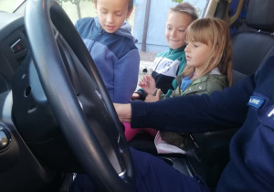 dzieci oglądają wewnątrz radiowóz policyjny